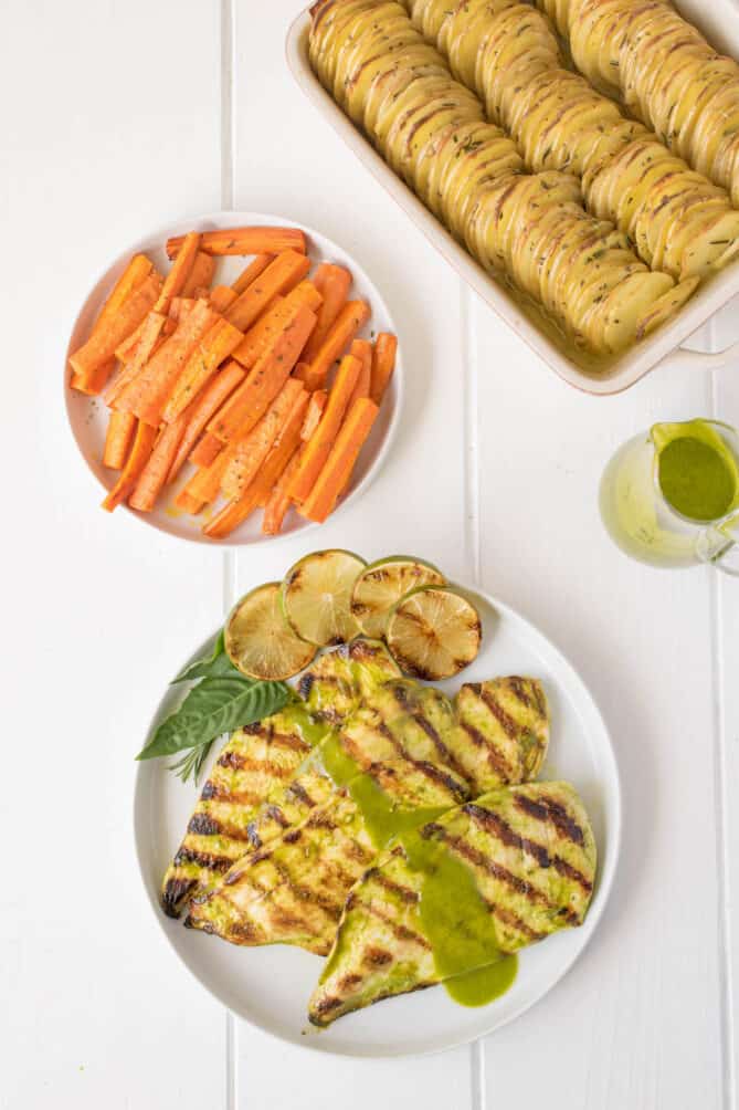 Grilled chicken with carrots and potatoes on plates