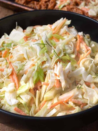 A black bowl filled with crunchy vegetable coleslaw