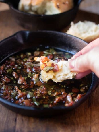 Dipping a piece of bread in to crispy bacon and sage in melted butter