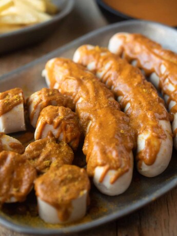 3 whole sausages and 1 cut into slices covered with currywurst sauce