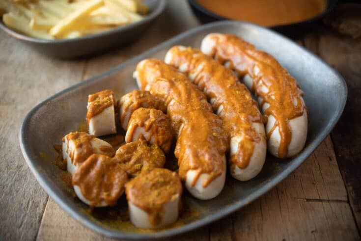 3 whole sausages and 1 cut into slices covered with currywurst sauce