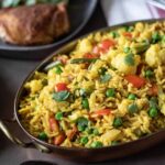 An oval dish of yellow rice and vegetables