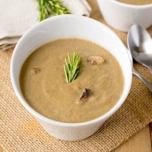 Smooth and creamy mushroom soup garnished with rosemary