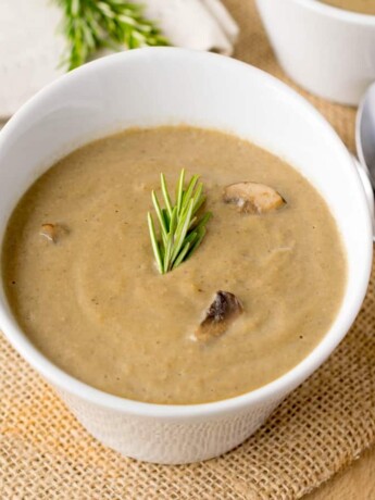 Smooth and creamy mushroom soup garnished with rosemary
