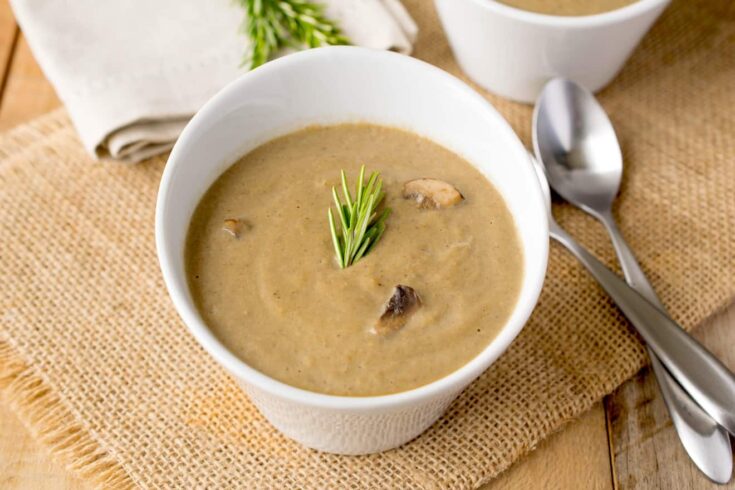 Smooth and creamy mushroom soup garnished with rosemary