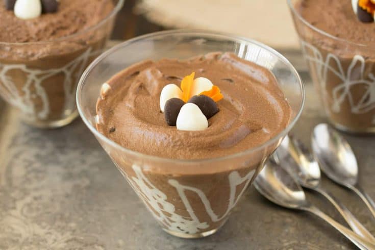 A closeup of a bowl of dark chocolate espresso mousse with 3 spoons