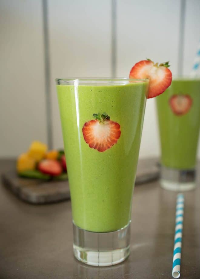 Detox green smoothie garnished with fresh strawberry slices