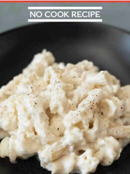 Thick white cheese sauce coated pasta garnished with black pepper