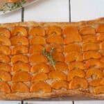 Vibrant orange slices of apricot on top of a puff pastry crust