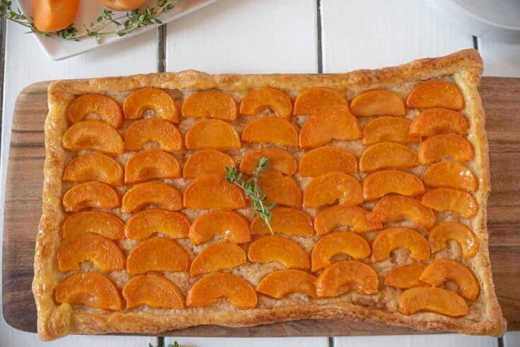 Vibrant orange slices of apricot on top of a puff pastry crust