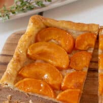 A square slice of apricot tart on a board