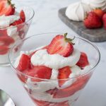 Layers of meringue, whipped cream and strawberries in a glass bowl