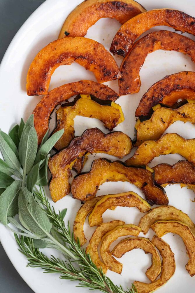 A closeup of pan roasted squash with sage and rosemary
