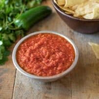 A bowl of Easy Restaurant-Style Red Salsa with cilantro and tortilla chips