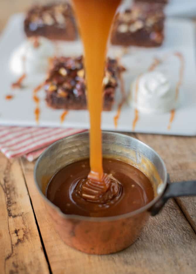 Drizzling salted caramel sauce into a pan