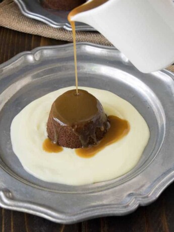 Sticky toffee pudding and English custard on a plate with toffee sauce