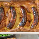 Toad in the hole in a casserole dish and on a plate with gravy being poured