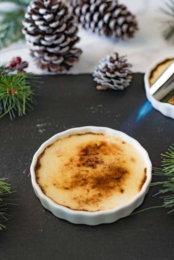 Using a kitchen blowtorch to brown and crisp sugar on top of creme brûlée