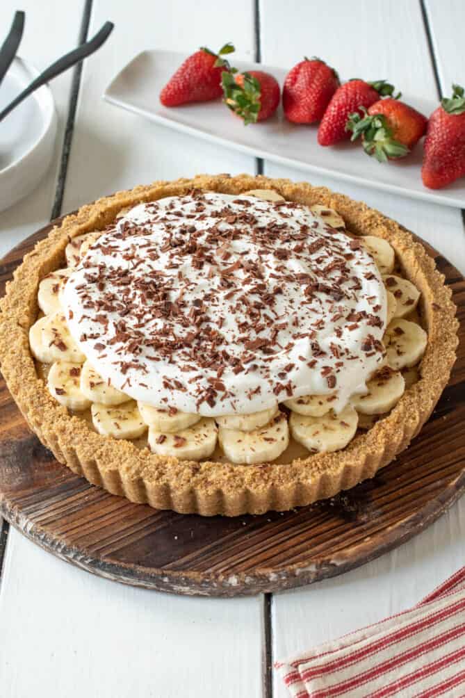 A banoffee pie with a cracker crust and layers of toffee banana and whipped cream