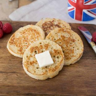 4 English crumpets with butter, berries and a cup of tea