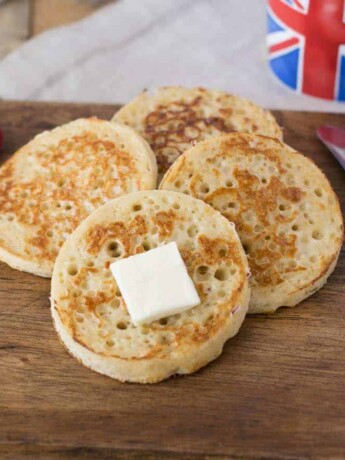 4 English crumpets with butter, berries and a cup of tea