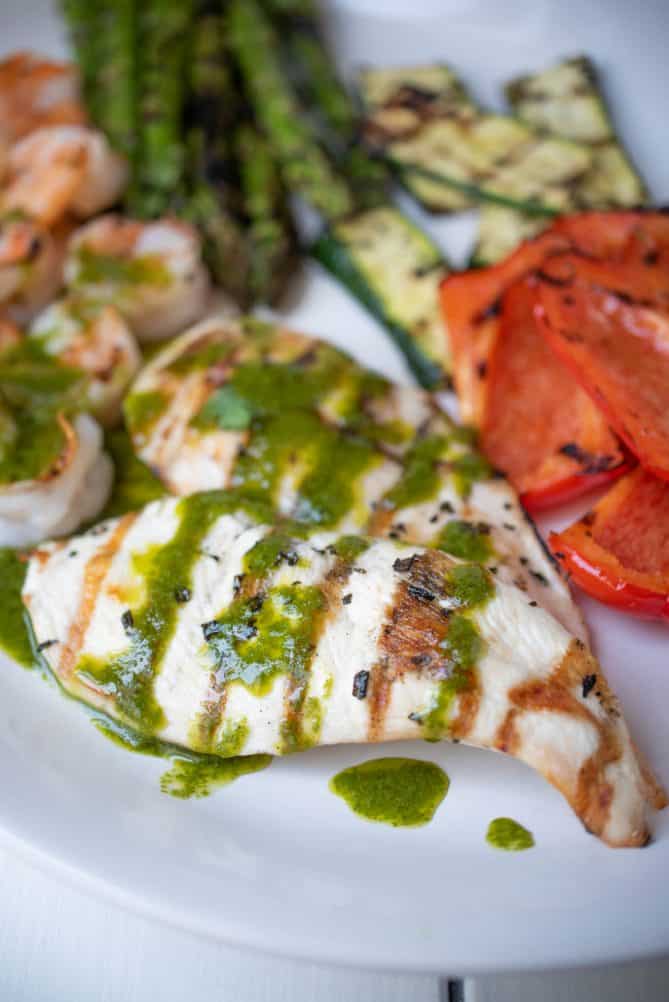 2 grilled chicken breasts topped with herb sauce
