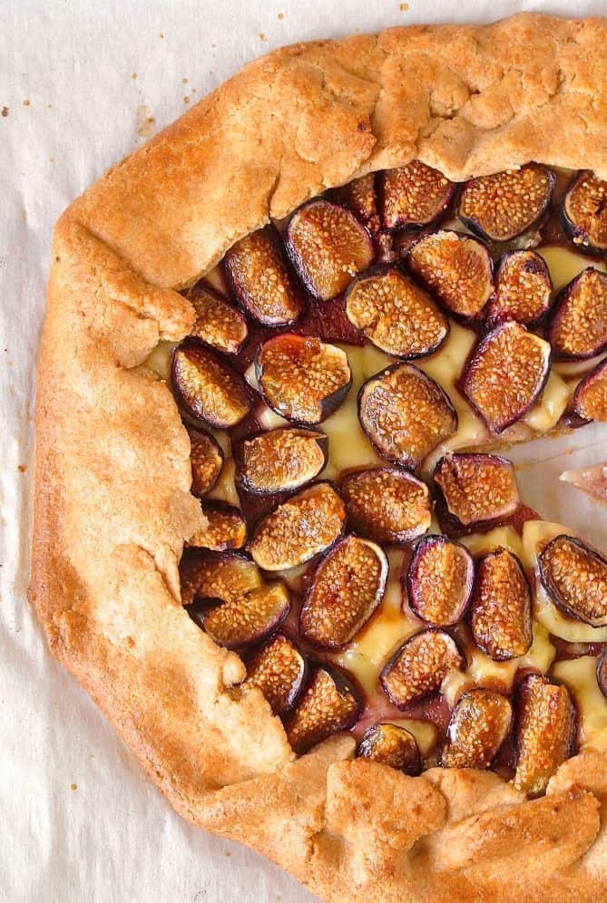 A bounty of fresh figs on top of a round pastry tart with brie cheese