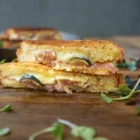 Fresh figs and prosciutto in a grilled cheese shown from the side showing the filling