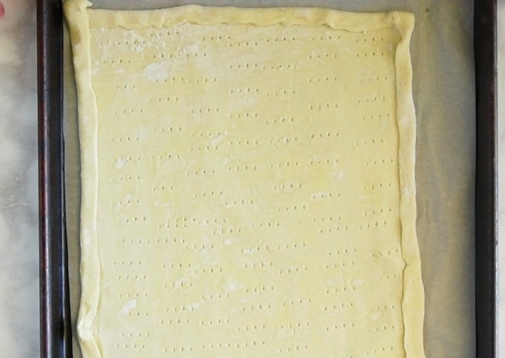 Puff pastry spread out on a baking sheet