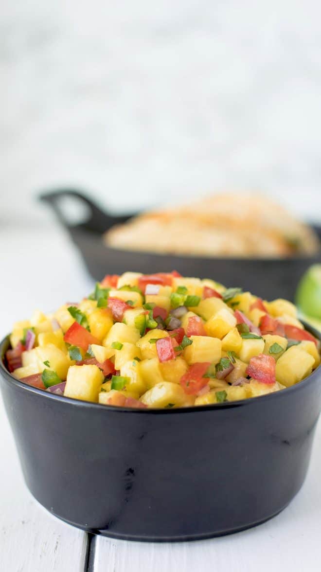 Pineapple salsa mounded in a bowl, viewed from the side