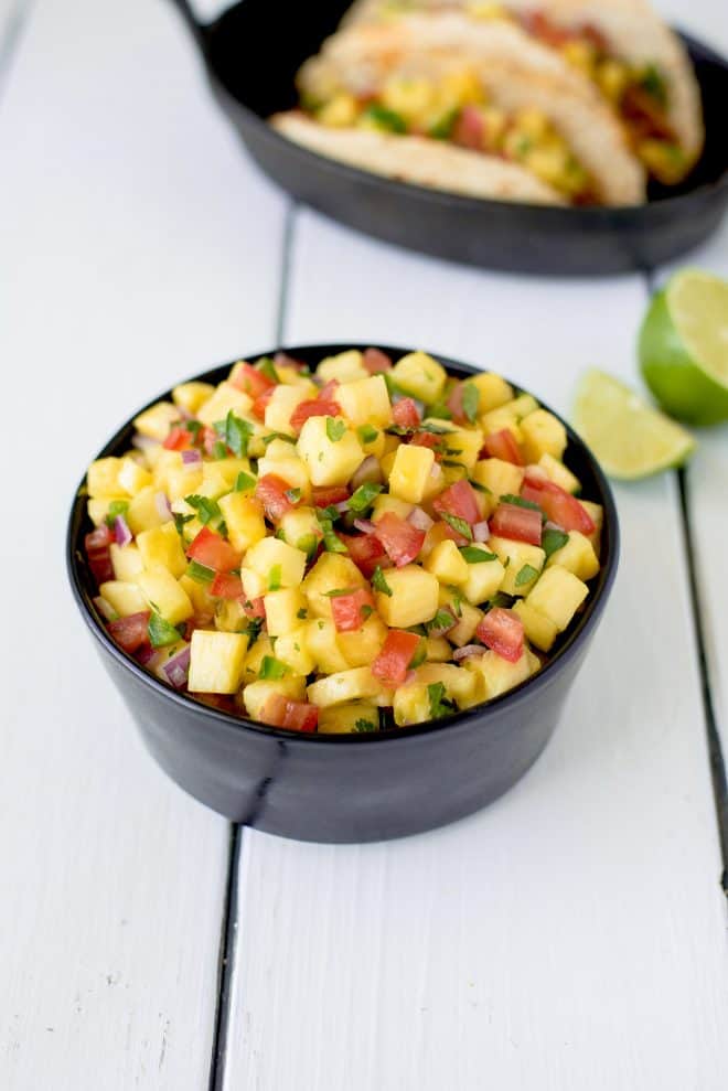 Fresh pineapple salsa in a bowl with tacos