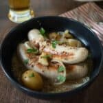 Pale sausages and potatoes stew in a bowl