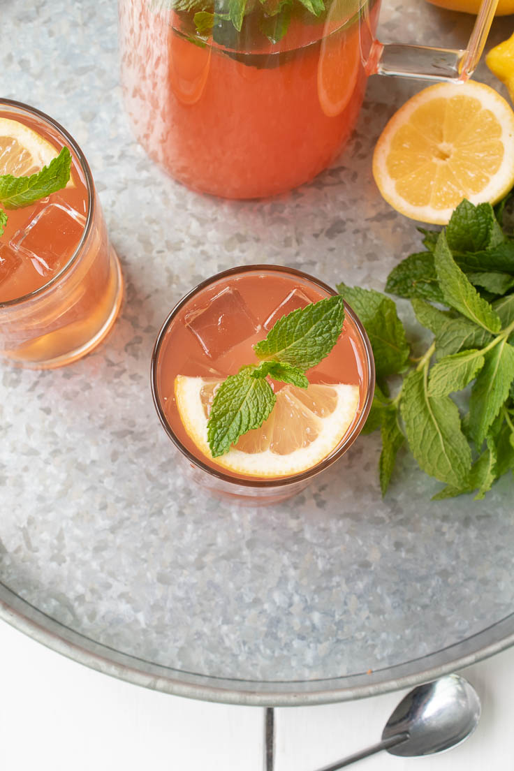 A top view into the glass of the lemonade showing a slice of lemon and fresh mint