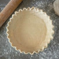 Gluten free dough in a pie dish ready for the filling