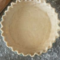 Gluten free pastry in a pie pan with fluted edges viewed from overhead