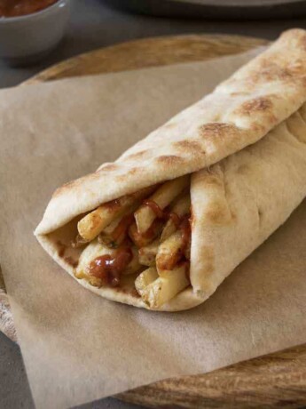 A naan wrapped around chips/French fries with Indian spiced ketchup