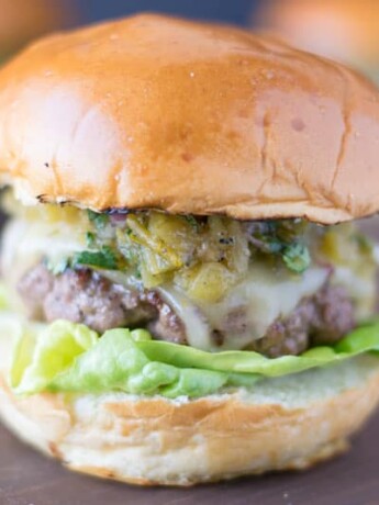 The burger from the side showing the melted cheese, chiles and lettuce