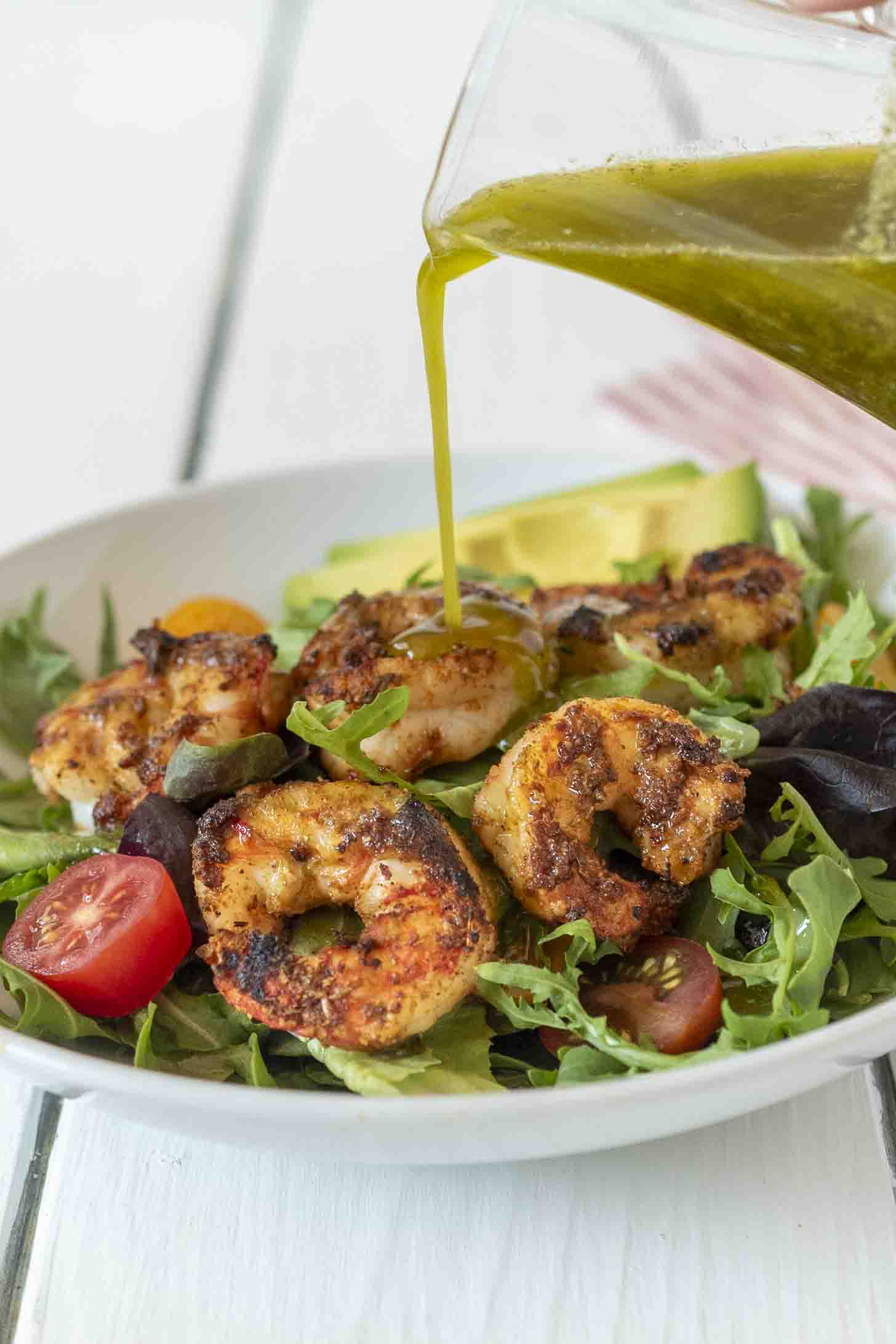 Pour green cilantro vinaigrette over shrimp and salad