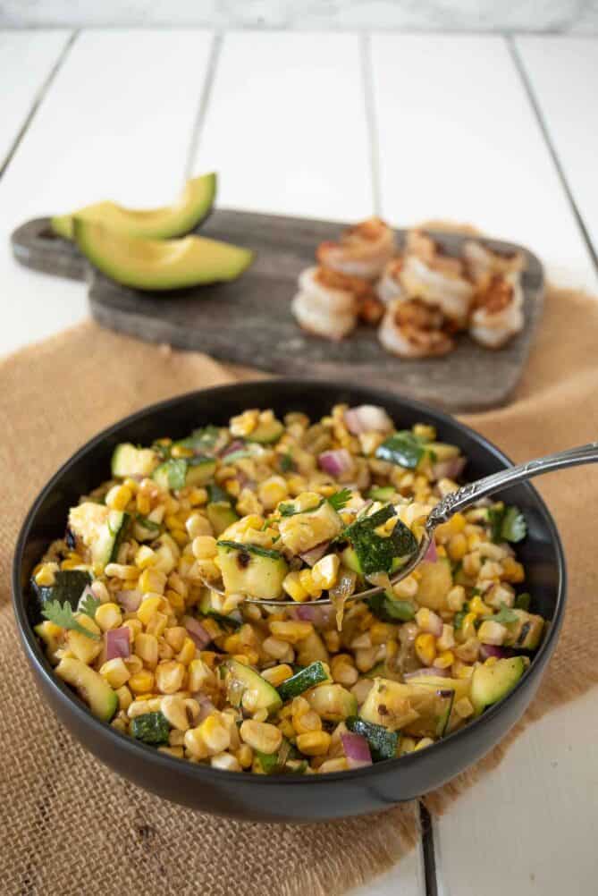 A spoonful of grilled corn and squash.