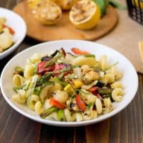 A white bowl of grilled spring vegetable pasta salad