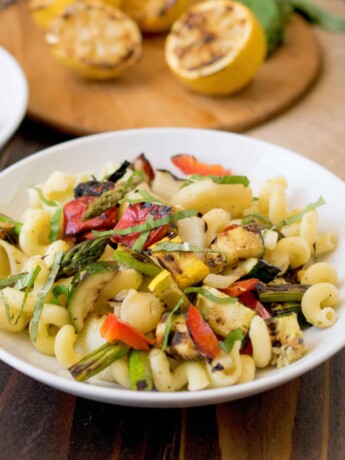 A white bowl of grilled spring vegetable pasta salad