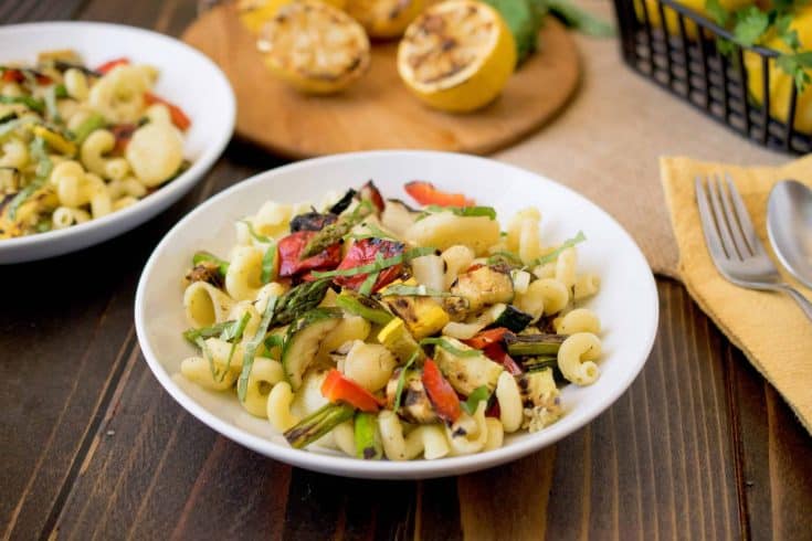 A white bowl of grilled spring vegetable pasta salad
