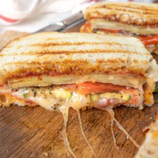 Grilled eggplant, zucchini bell pepper and cheese oozing from the panini