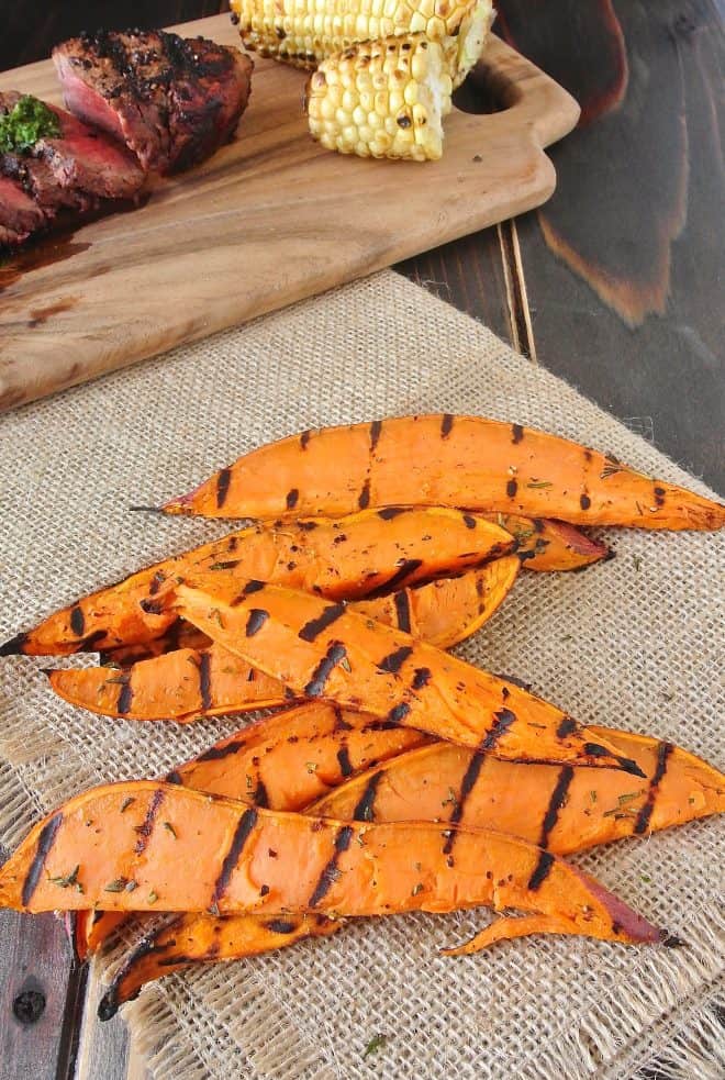 Grilled sweet potato slices with steak and corn in the background