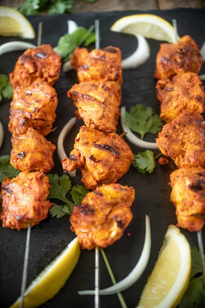 A closeup of grilled tandoori chicken that has been