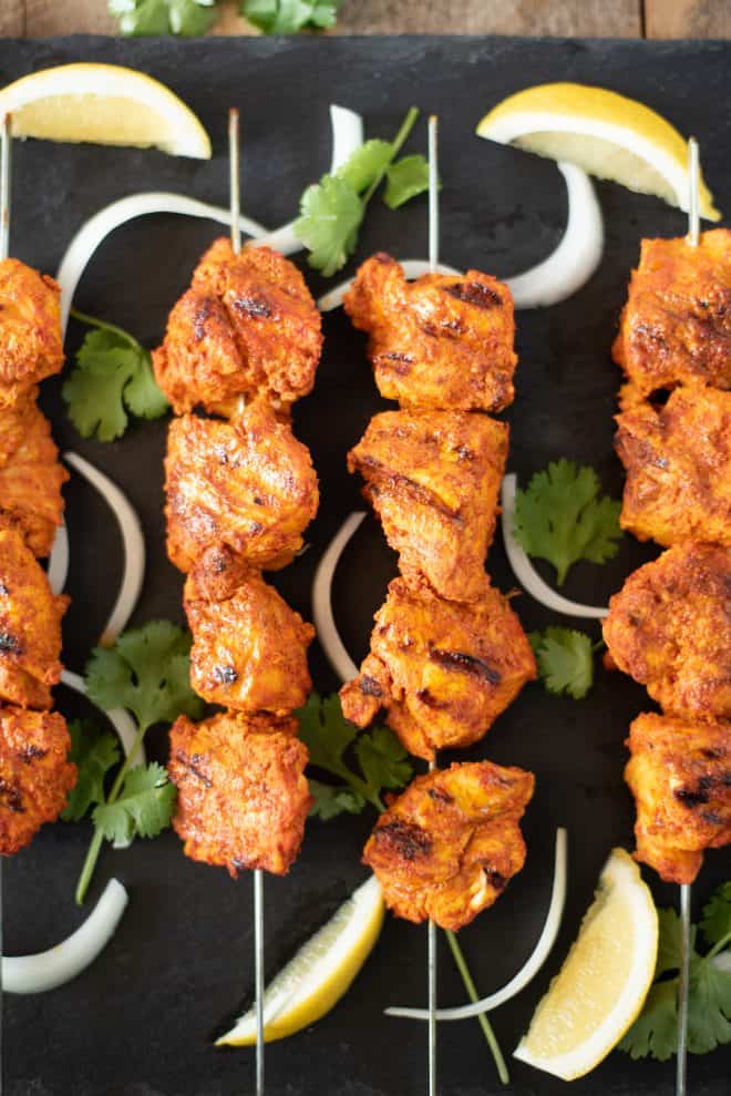 Grilled Tandoori Chicken Kebabs brings everyones favorite tandoori Indian dish into our own kitchens. Chicken is marinated in yogurt and  delicious Indian spices then grilled to achieve the closest flavor you can get without a tandoor oven. #tandoorichicken #grilled #indian
