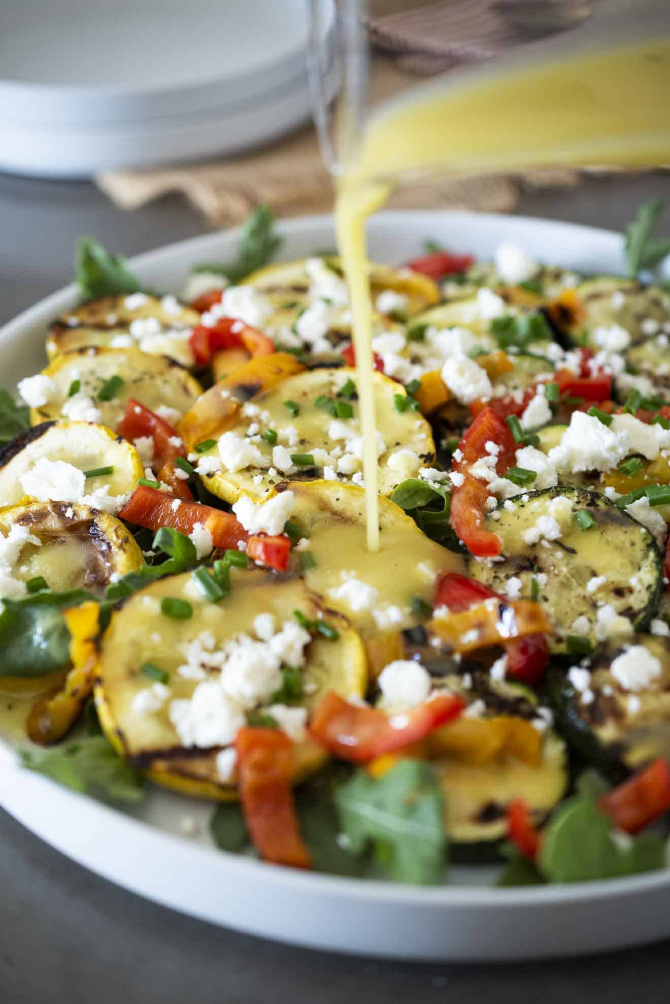 Drizzling Dijon vinaigrette over grilled zucchini