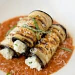 3 rolled sliced of eggplant filled with ricotta cheese
