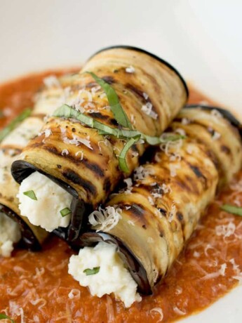 3 rolled sliced of eggplant filled with ricotta cheese