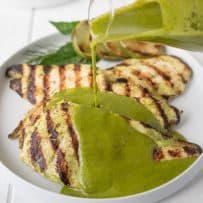 Perfectly grilled chicken with vibrant green herb sauce